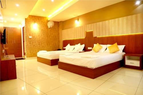 a hotel room with two beds and a bathroom at Wayanad Royal Crown in Kalpetta