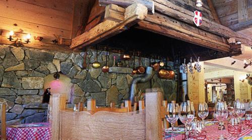 a dining room with a table with wine glasses at Hôtel Le Kandahar in Châtel