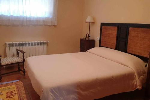 1 dormitorio con 1 cama blanca grande y 1 silla en Finca la barrosa ciudad y campo juntos, en Zamora