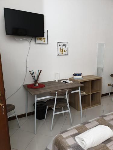 a room with a desk and a tv on a wall at Alba central City in Palermo