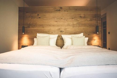 a large bed with white sheets and pillows at Hotel & Appartements Alpenresidenz Viktoria in Neustift im Stubaital