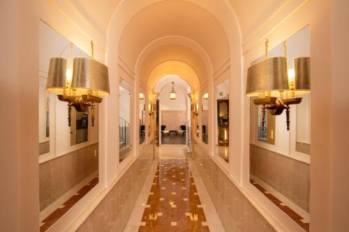 a hallway in a building with two lights on the walls at Hotel Del Corso in Rome