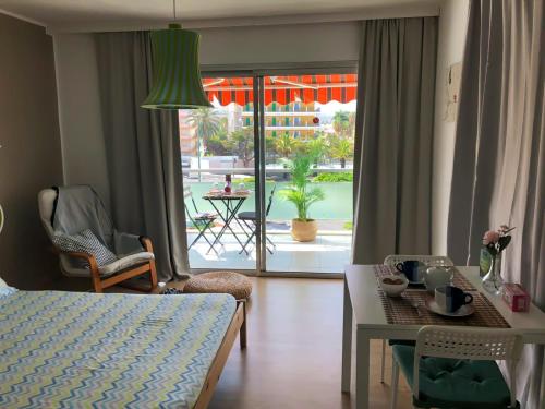 a living room with a bed and a table and a view of a patio at Agave Paradise in Puerto de la Cruz