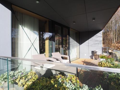 a house with white chairs on a balcony at CHALEYOTT Mountain Apartments in Harrachov