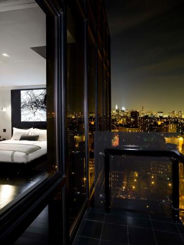 a bedroom with a bed and a view of a city at Sixty LES in New York