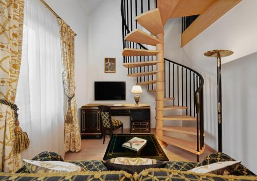 a living room with a spiral staircase and a desk at Hotel Schwarzer Adler Innsbruck in Innsbruck