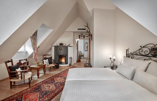 a bedroom with a bed and a fireplace at Hotel Schwarzer Adler Innsbruck in Innsbruck