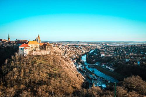 a castle on a hill next to a river at Penzion U Kapličky in Znojmo