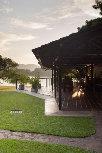 a wooden pavilion with a view of the water at Mapakada Village - Mahiyanganaya in Mahiyangana