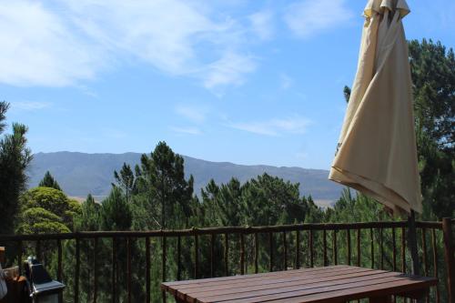 an umbrella sitting on top of a wooden fence at Otium Oasis Glamping & Camping in Hartebeest Rivier