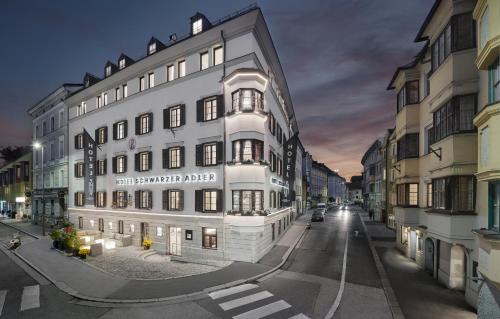 um grande edifício branco numa rua da cidade à noite em Hotel Schwarzer Adler Innsbruck em Innsbruck