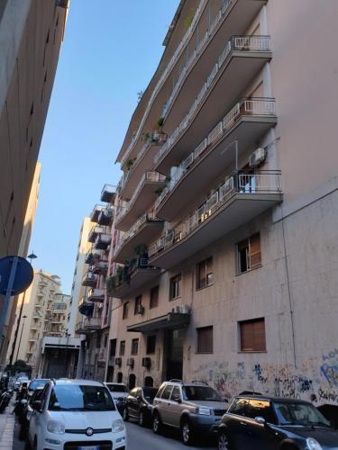 a tall building with cars parked on a city street at Alba central City in Palermo