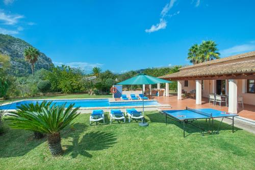 ein Haus mit einem Pool mit zwei Tischen und Stühlen in der Unterkunft Owl Booking Villa Romeu - 10 Min Walk to the Old Town in Pollença