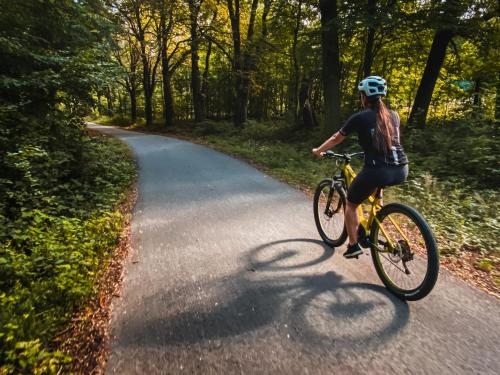 a woman riding a bike down a road at Penzion U Kapličky in Znojmo