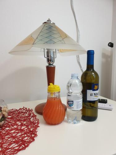 a table with a lamp and some bottles of wine at Alba central City in Palermo