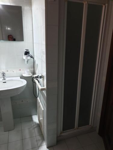 a bathroom with a glass shower door next to a sink at Alba central City in Palermo
