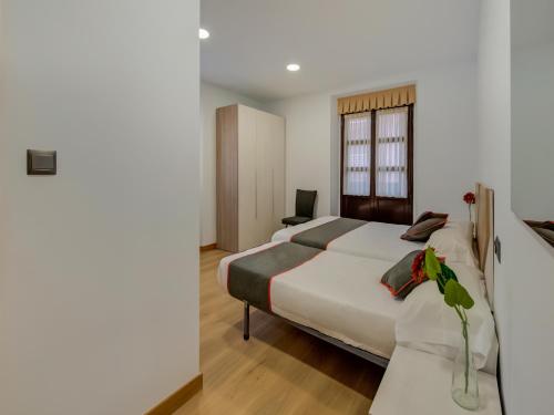a bedroom with a bed and a desk with a laptop at Hostal Restaurante La pinta in Ampuero