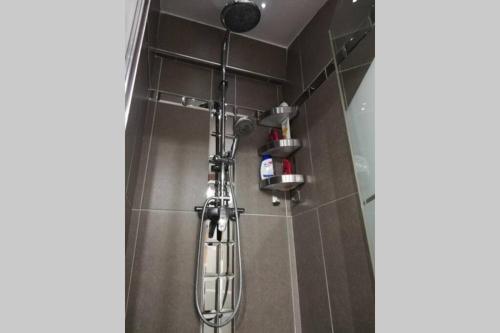 a shower in a bathroom with a glass shower head at Maison de village de caractère in Nébian