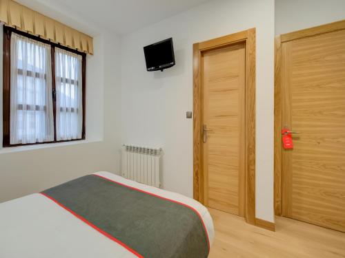 a bedroom with a bed and a wooden door at Hostal Restaurante La pinta in Ampuero