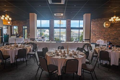 una sala de banquetes con mesas y sillas con manteles blancos en Broadcroft Hotel en Kirkintilloch