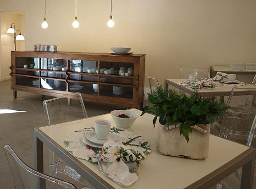 a living room with a table and chairs with a cabinet at Hotel Villa Moron in Negrar