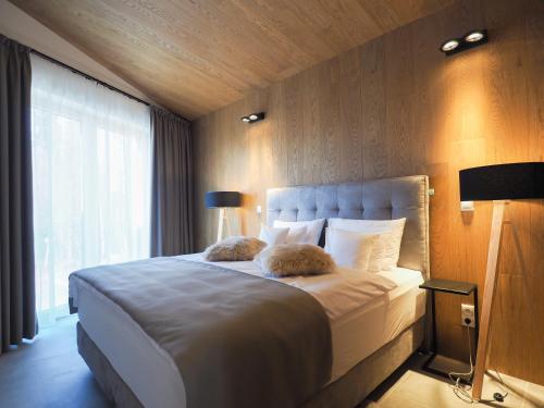 a bedroom with a large white bed with a window at CHALEYOTT Mountain Apartments in Harrachov