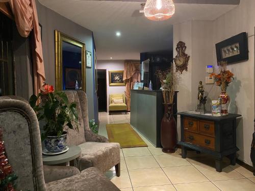 a living room with two chairs and a table at Marion Lodge in Johannesburg