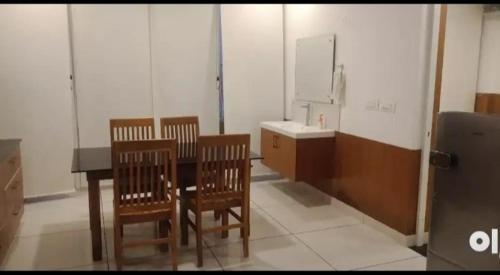 um quarto com uma mesa e cadeiras e um lavatório em QUILON BEACH Inn em Coulão