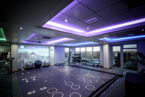 a room with a gym with purple lighting at The Tytherington in Macclesfield