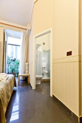 ein Schlafzimmer mit Bett und ein Badezimmer mit Toilette in der Unterkunft B&B MediNaples in Neapel