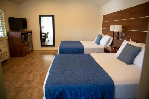 a hotel room with two beds and a television at Sterling Inn in Santa Clara
