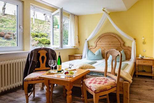 a bedroom with a bed and a table and chairs at Hotel Villa Tummelchen in Cochem