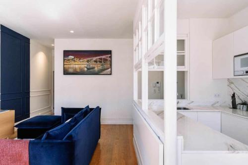 Una sala de estar con un sofá azul y una cocina. en Bruno's Wine House, en Vila Nova de Gaia