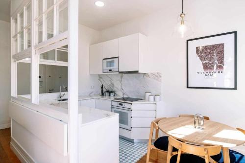 a kitchen with white cabinets and a wooden table at Bruno's Wine House in Vila Nova de Gaia