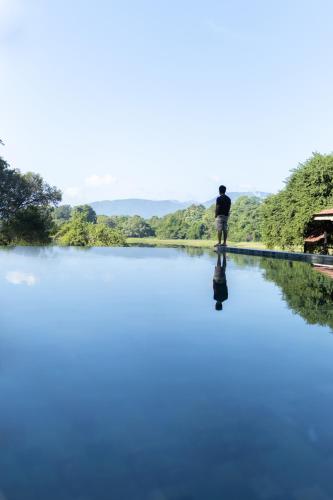 a man standing on the edge of a river at Mapakada Village - Mahiyanganaya in Mahiyangana