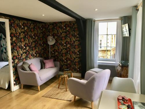 a living room with a couch and chairs and a window at Au coeur des Remparts in Boulogne-sur-Mer