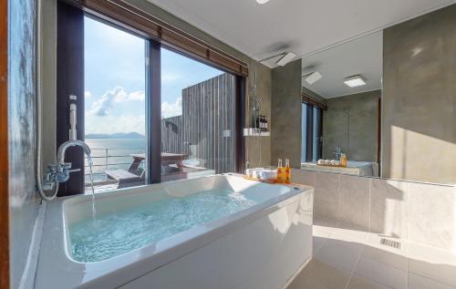 baño con bañera y ventana grande en Namhae Whale's Dream, en Namhae