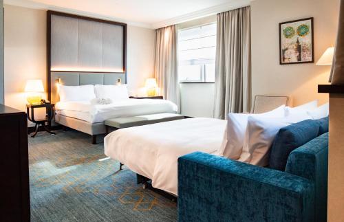 a hotel room with two beds and a couch at InterContinental Warszawa by IHG in Warsaw