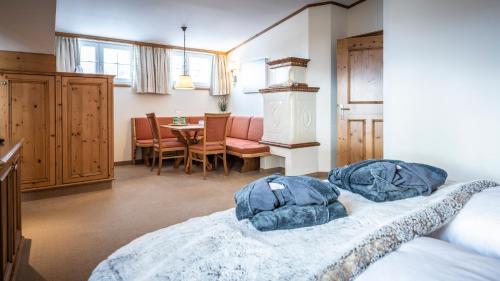a bedroom with a bed and a dining room at Anthony´s Alpin Hotel Garni in Lech am Arlberg