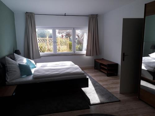 um quarto com uma cama e uma janela em Ferienwohnung Zürcher em Chieming