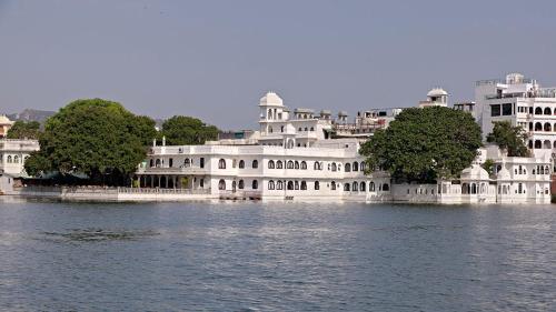 a large white building in the middle of the water at Amet Haveli - A Heritage Hotel Udaipur in Udaipur