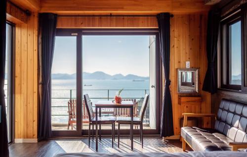 a living room with a table and a view of the ocean at Namhae Whale's Dream in Namhae