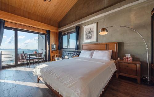 ein Schlafzimmer mit einem großen Bett und einem großen Fenster in der Unterkunft Namhae Whale's Dream in Namhae