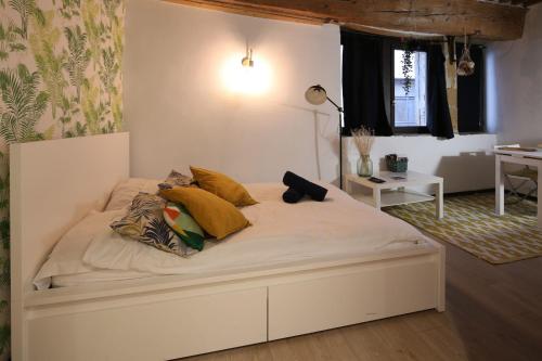 - un lit blanc avec des oreillers jaunes dans l'établissement Charming Studio Centre Ville De Lyon, à Lyon