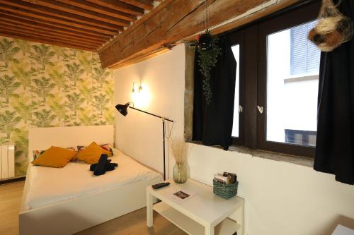 une chambre avec un lit blanc et une table dans l'établissement Charming Studio Centre Ville De Lyon, à Lyon