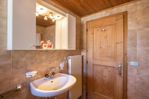 a bathroom with a sink and a wooden door at Appartamento primo piano in San Martino in Badia