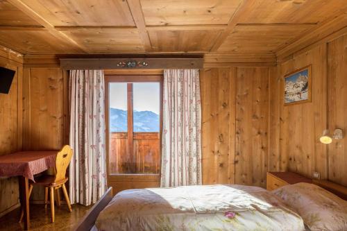 a bedroom with a bed and a large window at Appartamento primo piano in San Martino in Badia