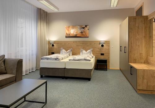 ein Hotelzimmer mit einem Bett und einem Sofa in der Unterkunft BELLEVUE-Boardinghouse in Lichtenfels