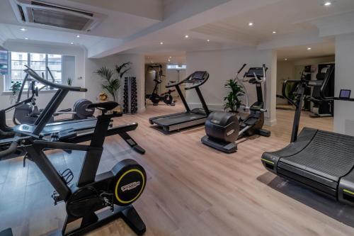 a gym with several exercise bikes and treadmills at Meliá White House Hotel Apartments in London