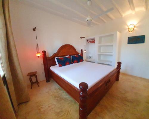 a bedroom with a wooden bed in a room at MOYO apartment in Pwani Mchangani